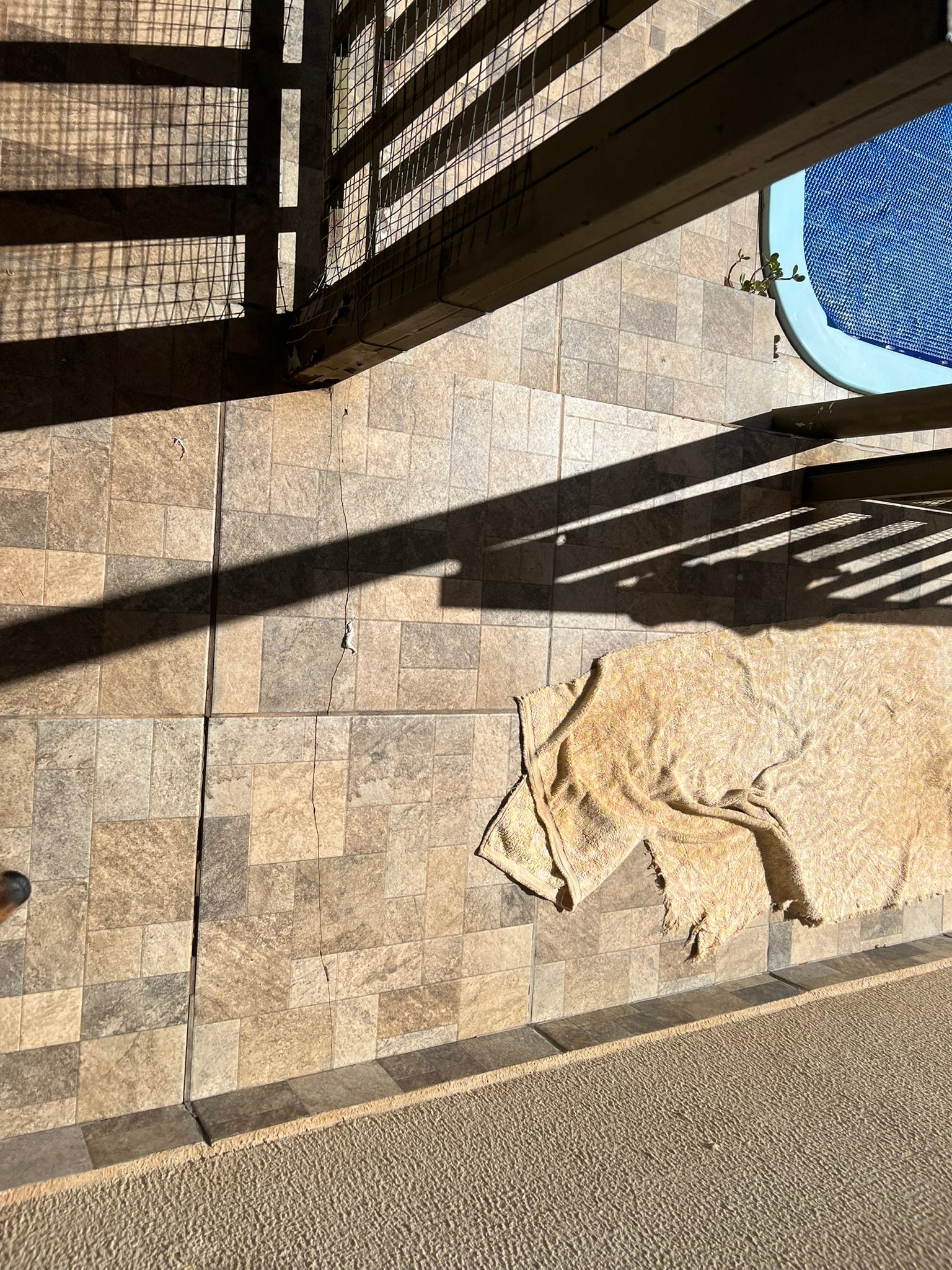 Piso externo com trinca atravessando várias peças, ao lado de uma piscina