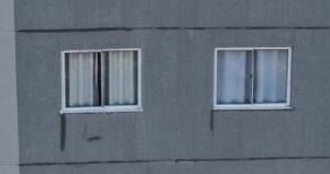 Fachada de edifício com escorrimento de água abaixo do peitoril da janela, foto aérea captada por drone