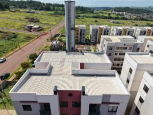 Vista aérea de edificação residencial com telhado cerâmico e fachada em tons de branco e vinho