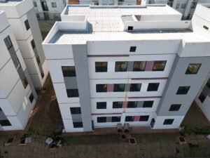 Vista aérea da fachada frontal de um bloco de condomínio residencial, captada por drone